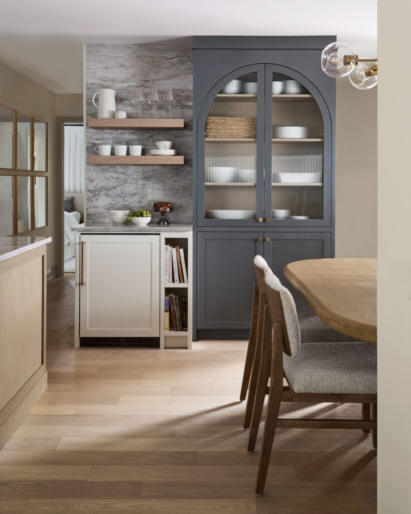 Renovated kitchen with arched cabinetry detail, new layout, light countertops, and modern appliances. Suburban Toronto home renovation by Erin Interiors, Durham Region Interior Designer.
