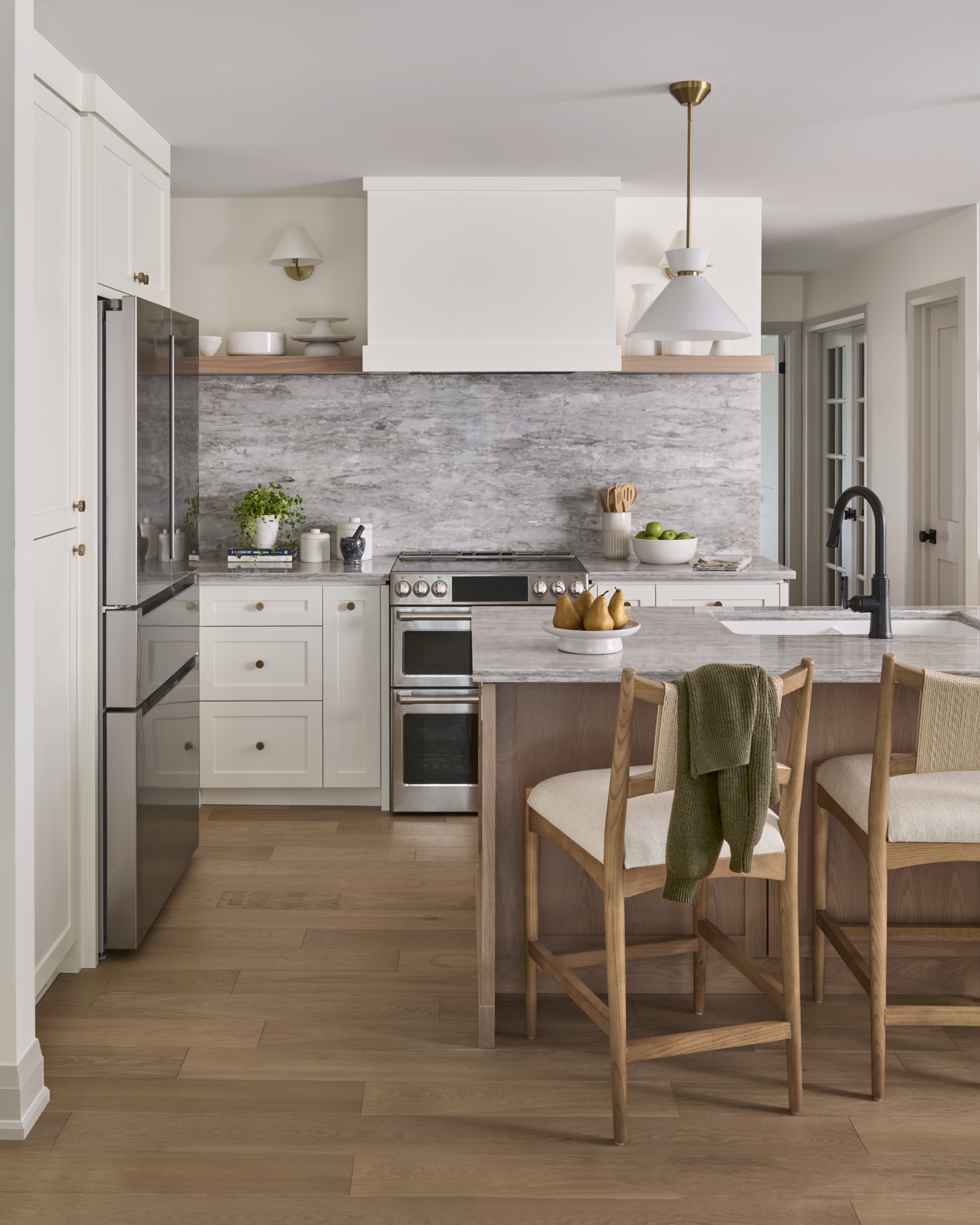 Renovated kitchen with arched cabinetry detail, new layout, light countertops, and modern appliances.