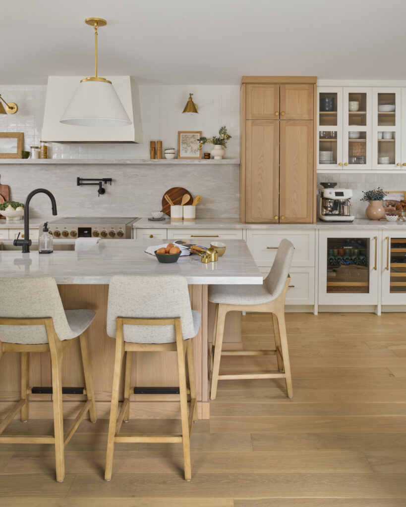 Kitchen island with Scandinavian bar stools and brass and white pendant lights